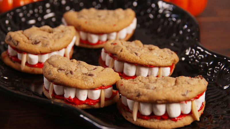 Vámpírfogsor<br /><br />Ez a vicces halloweeni édesség készülhet bármilyen saját készítésű vagy bolti kekszből is. A fogak kisméretű pillecukorból, a vámpírfogak pedig mandulából vannak. A „véres” hozzávalót pedig piros ételszínezővel megfestett cukormázból is elkészítheted. Ha nem akarsz a cukormázzal bíbelődni, a piros színű lekvár is tökéletes megoldás lesz. Szuper harapnivaló a tök ünnepére.