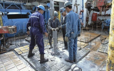 A037-00093 Oil workers on drilling floor of a drilling rig in th