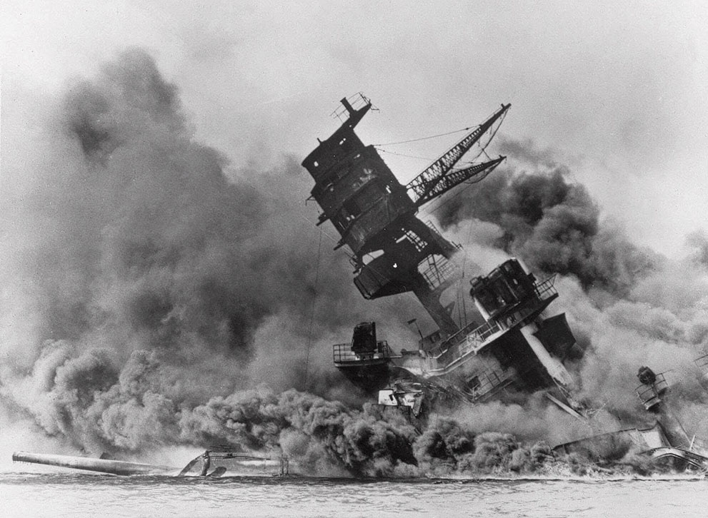 The battleship USS Arizona belches smoke as it topples over into