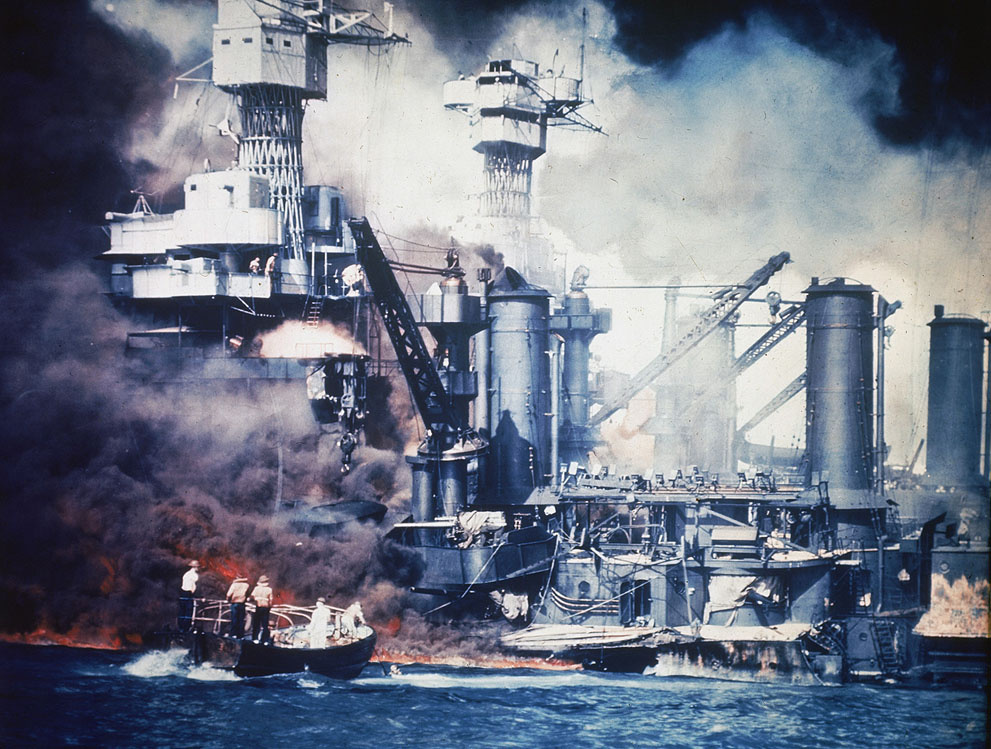 A small boat rescues a USS West Virginia crew member from the wa