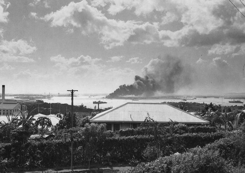 Seen from a distance, the Battleship Arizona burns as it sinks i