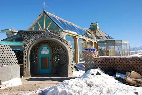 Earthship-ingresso-con-vetri-e-pannelli-solari-indipendente-ener