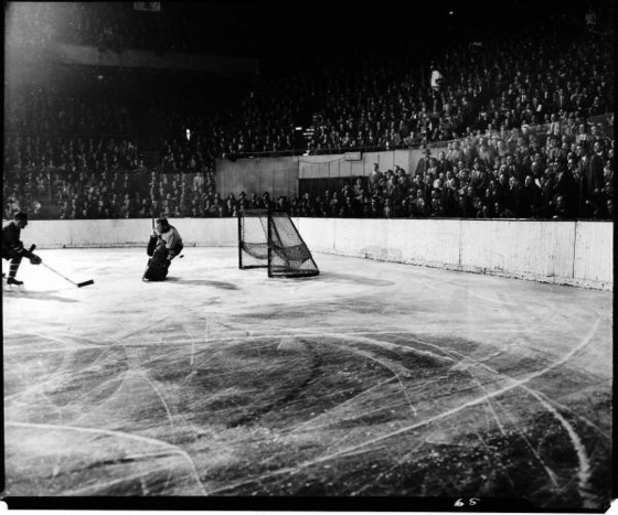 Hockey puck flying past Maple Leafs goalie in game between NY Ra