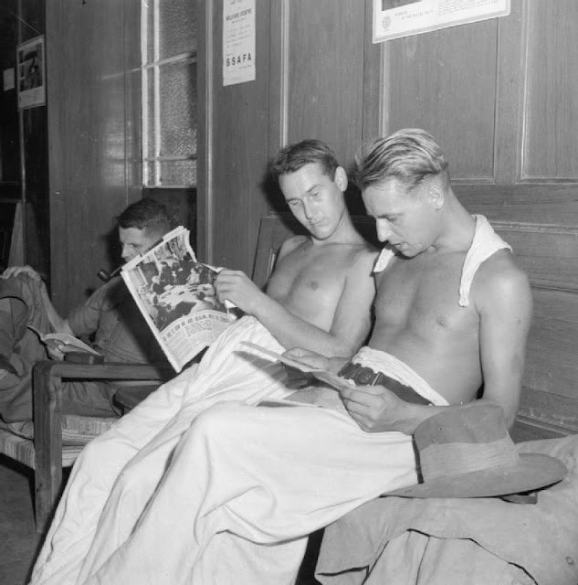 former POWs reading the first British newspapers they have seen 