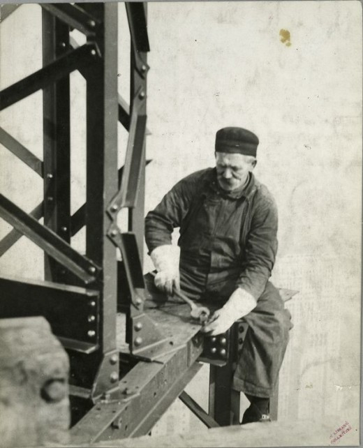 Worker-attaching-a-bolt-onto-a-beam-1931-520x642