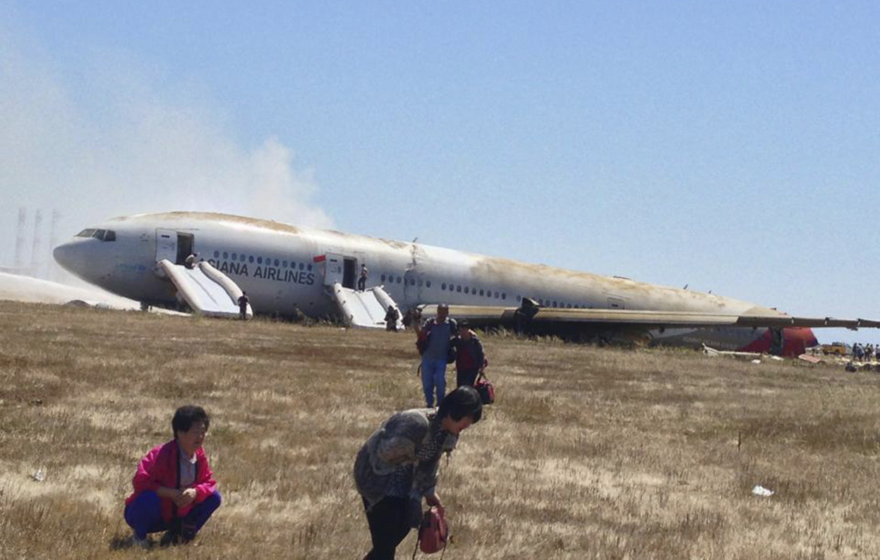 Passengers evacuate the Asiana Airlines Boeing 777, after a cras