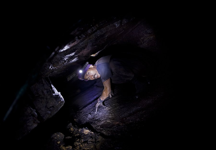 a-miner-makes-his-way-through-one-such-tunnel-at-a-mine-in-the-d