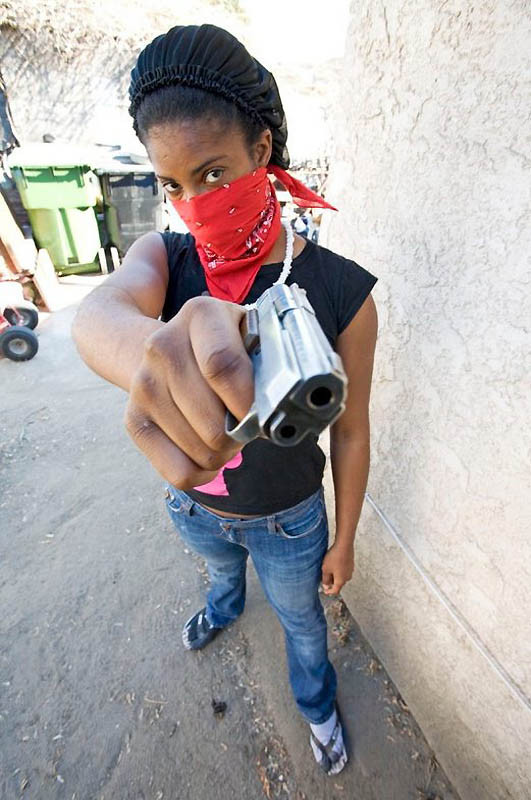 Egy nő a bandából megmutatja a fegyverét