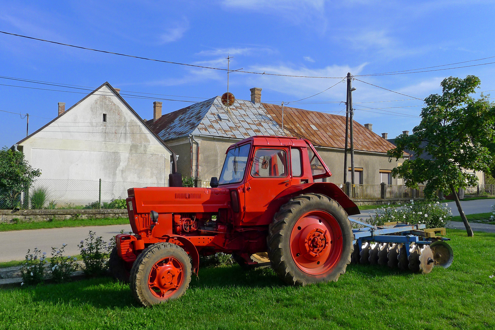 Piros traktor boronával